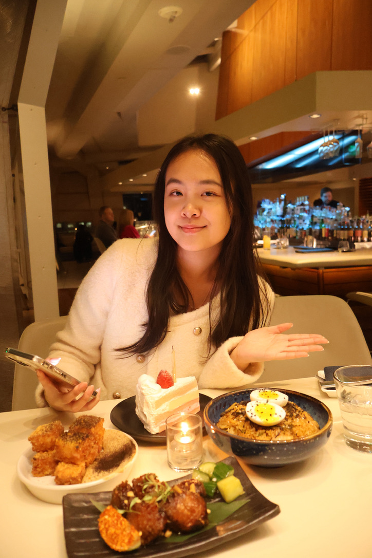 Xintong at a restaurant with a variety of dishes
